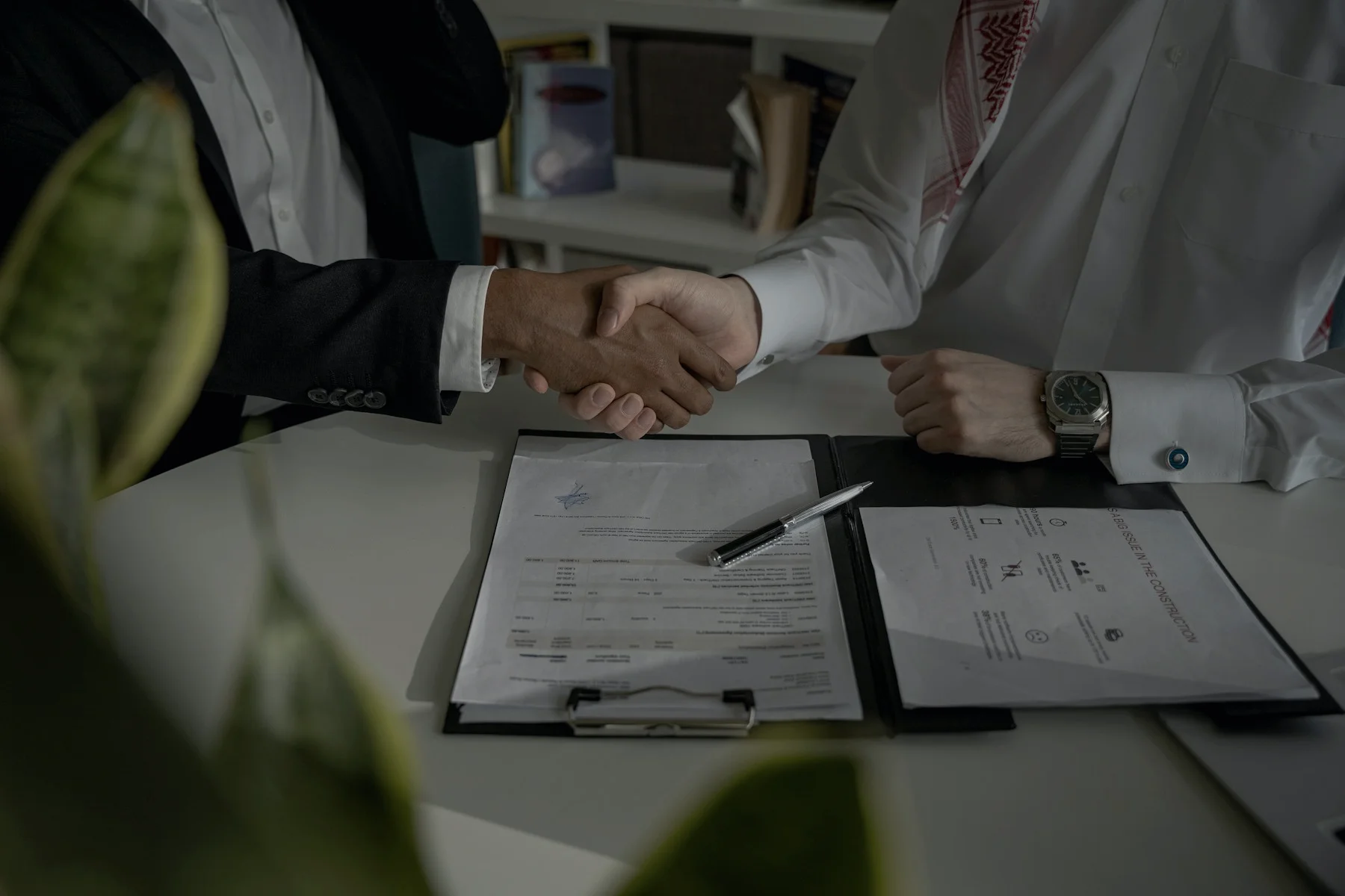 Close crop of a handshake over a signed mandate agreement