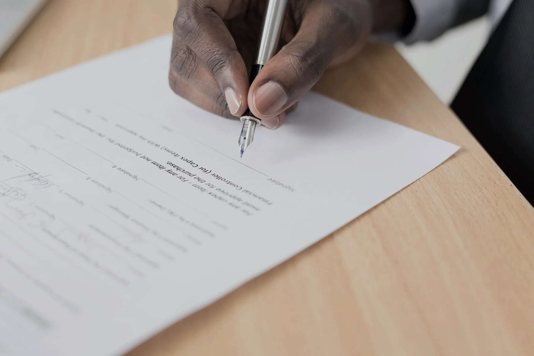Close crop of hands signing investment documents
